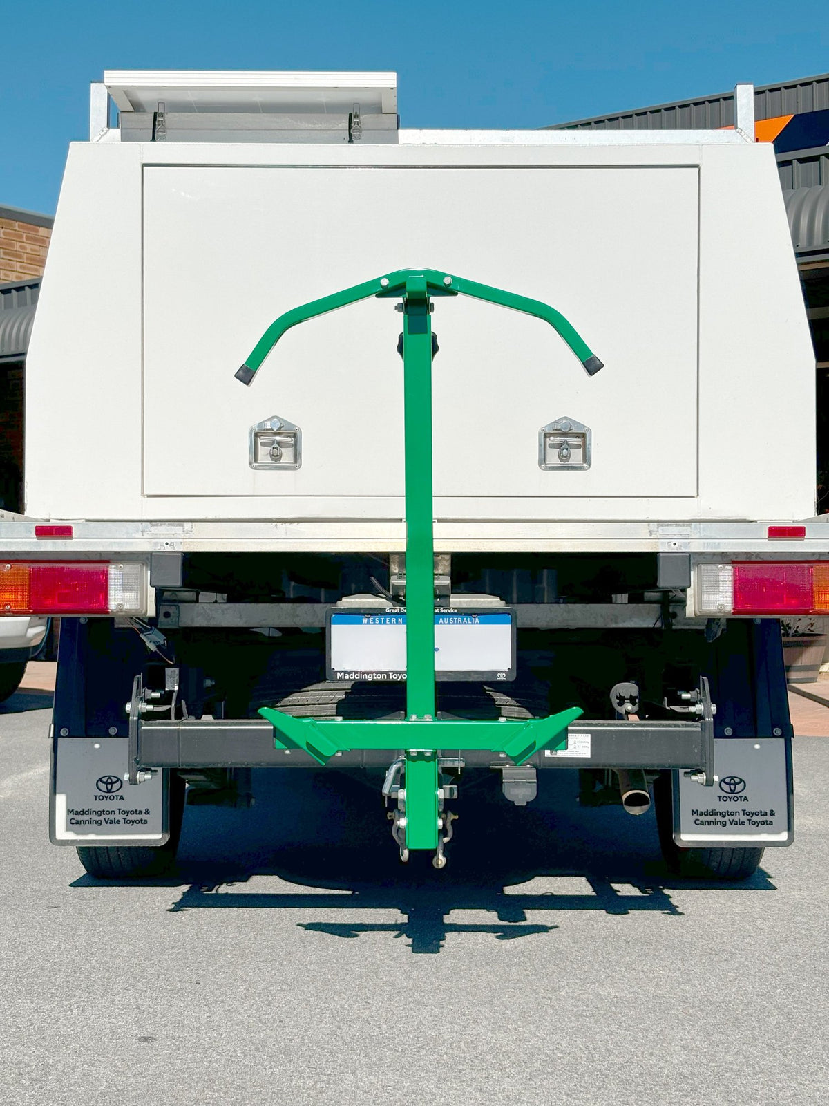 Barry wheelbarrow carrier mounted in a tow hitch receiver, holding a wheelbarrow vertically